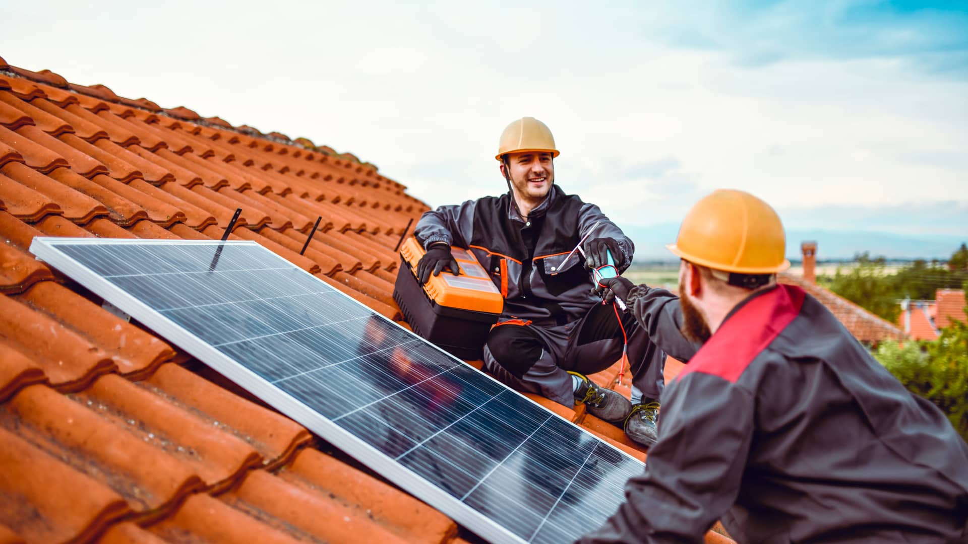 Técnicos de edp instalando placas solares de energía renovable en una casa