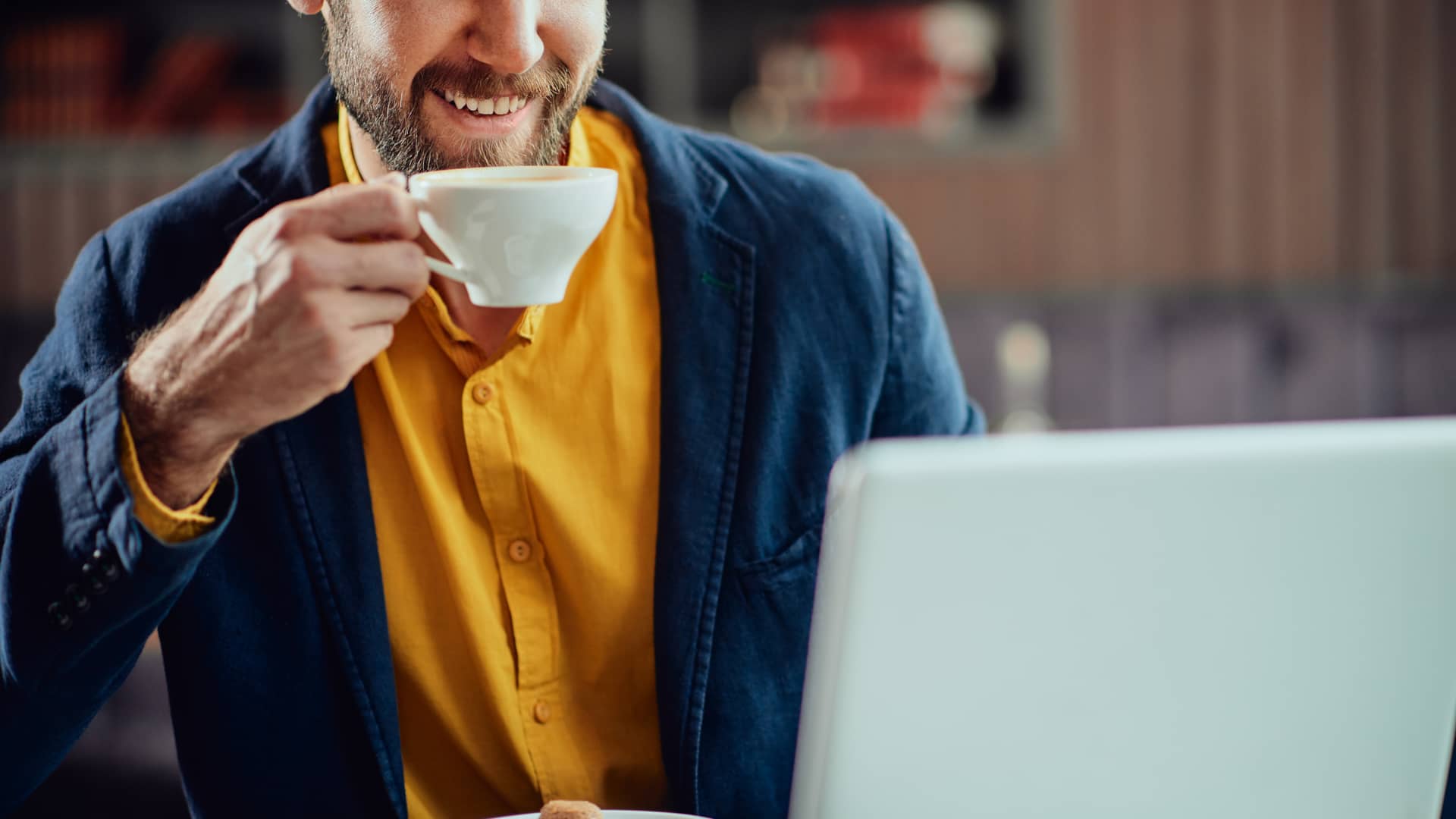 Hombre sonriente informandose de tarifa tur de endesa mientras toma un café