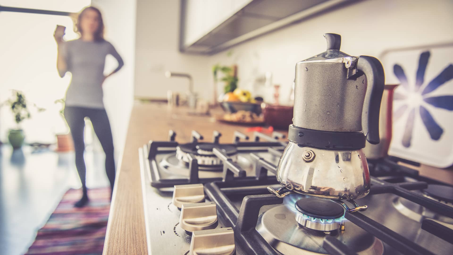 Mujer haciendo café en cocina de gas