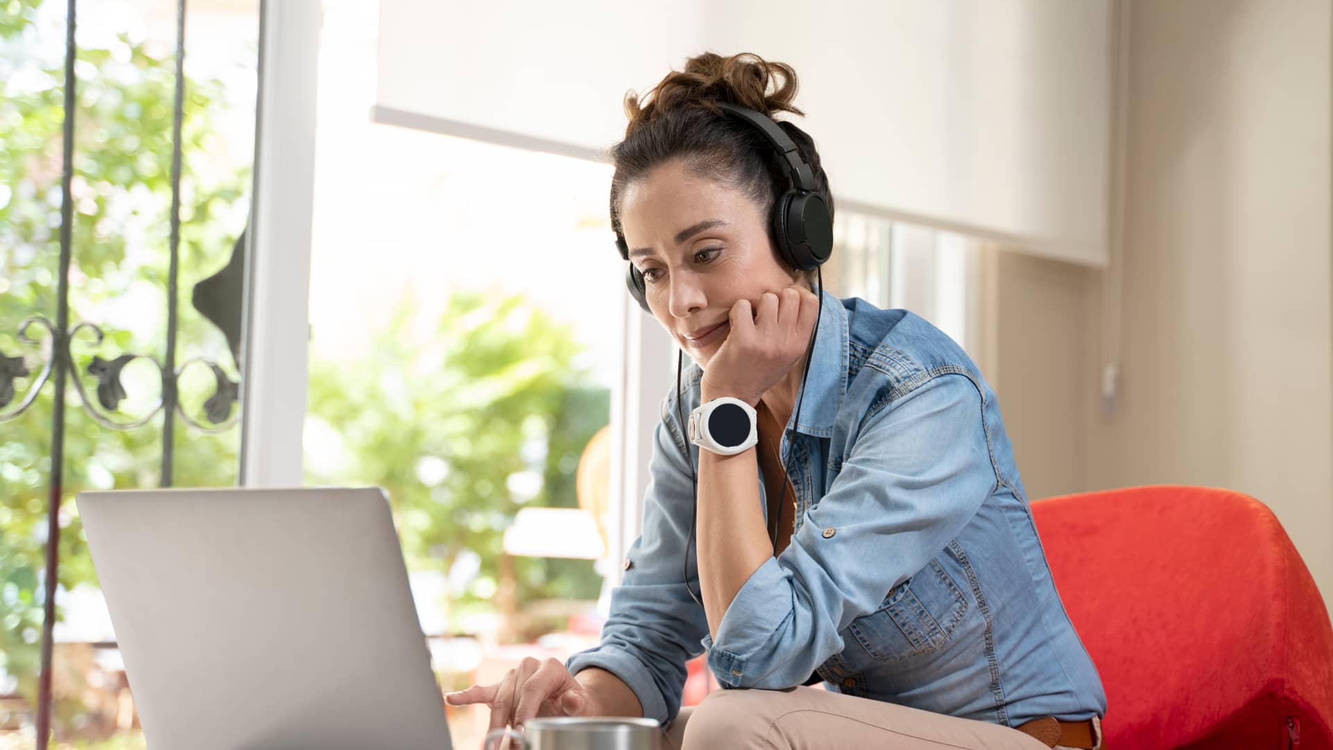 Mujer viendo tarifas de holaluz en su portátil mientras escucha música