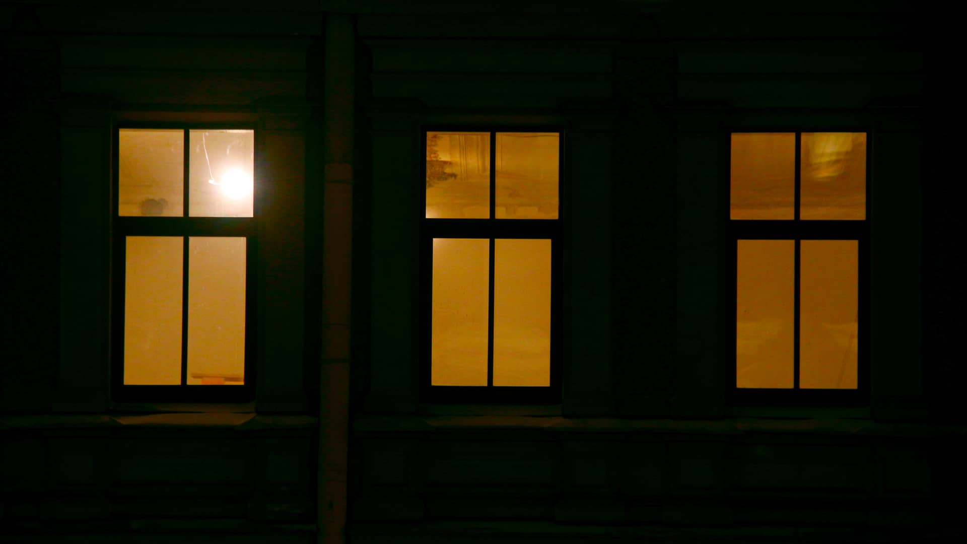 ventanas con luz de una casa vistas desde la fachada de una familia que tiene una de las tarifas de discriminacion horaria de iberdrola