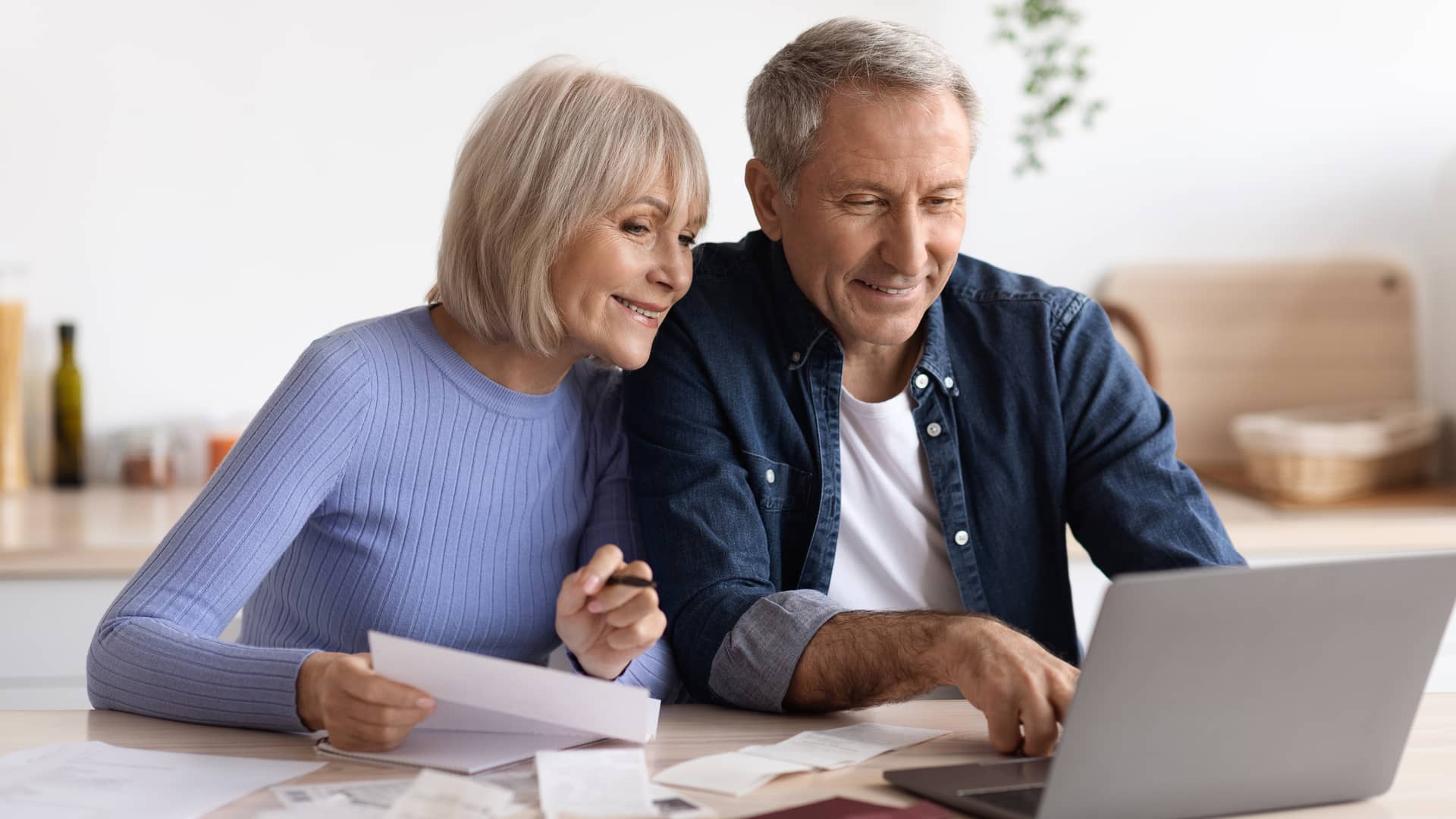 Una pareja de mediana edad revisa sus facturas del mes incluida su factura de luz de logos energía