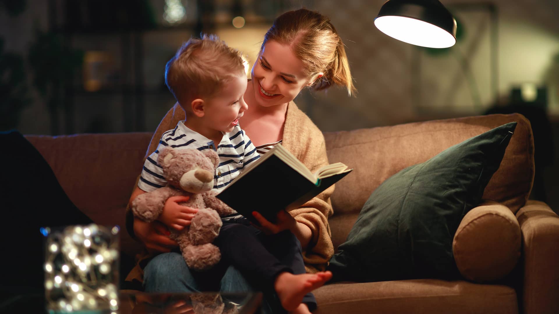 Mujer leyendo cuento a su hijo bajo la luz de naturgy