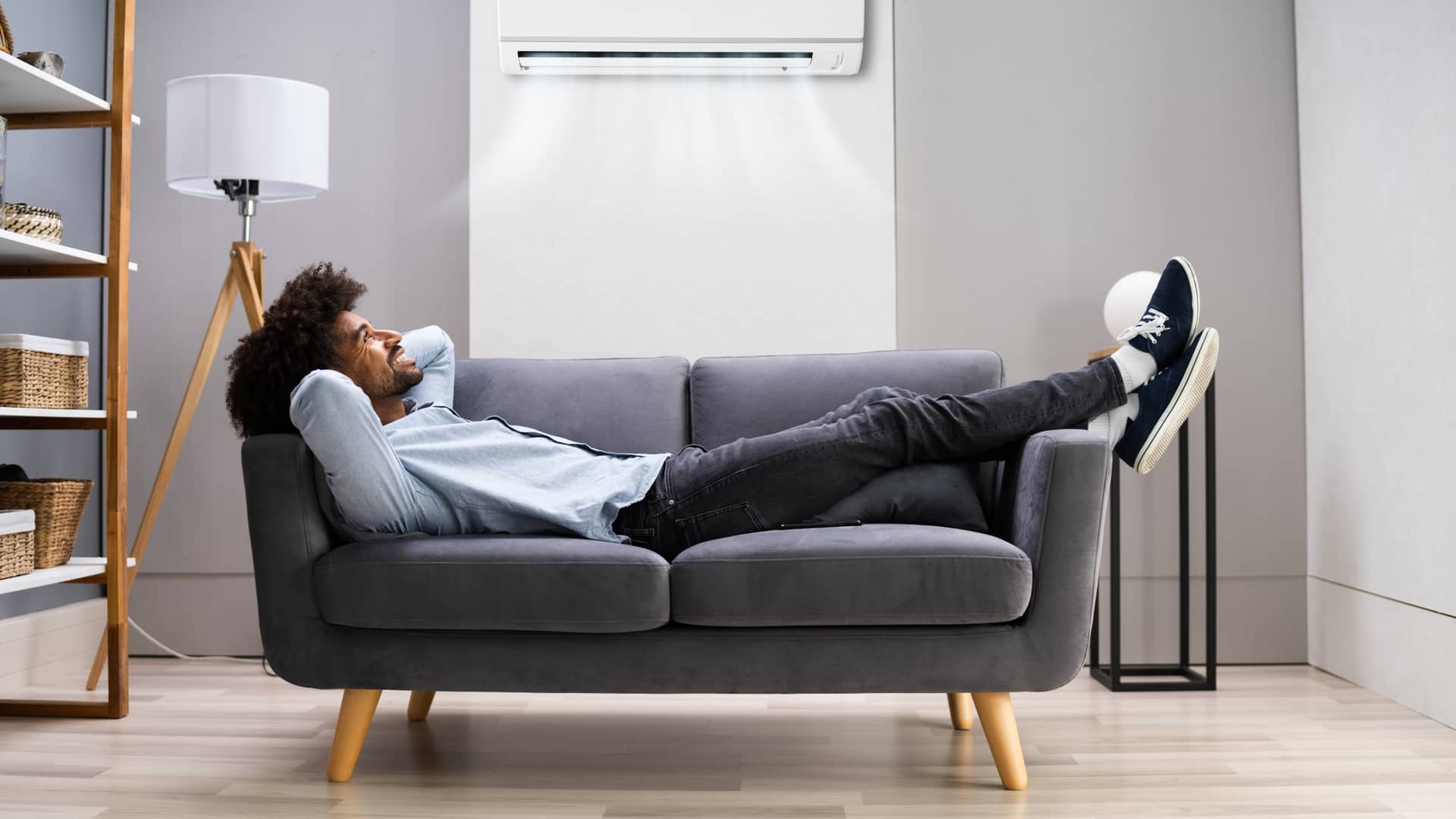 Hombre tumbado disfrutando del aire acondicionado en su casa gracias a su tarifa Nexus energía