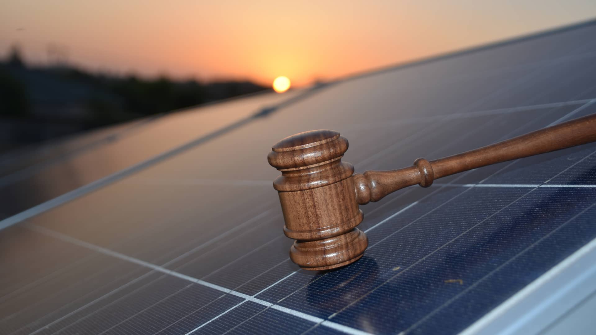 Mazo judicial sobre un panel solar símboliza las leyes entorno a esta energía renovable