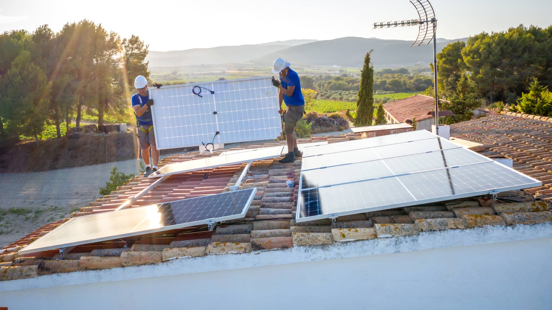 Dos personas en plena instalación de un kit de autoconsumo de energía solar