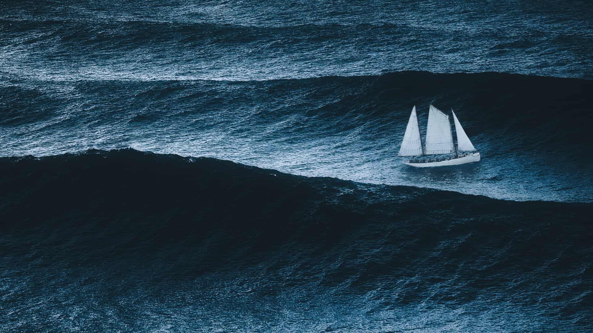 Velero en el mar con tormenta y grandes olas simboliza energía maremotriz