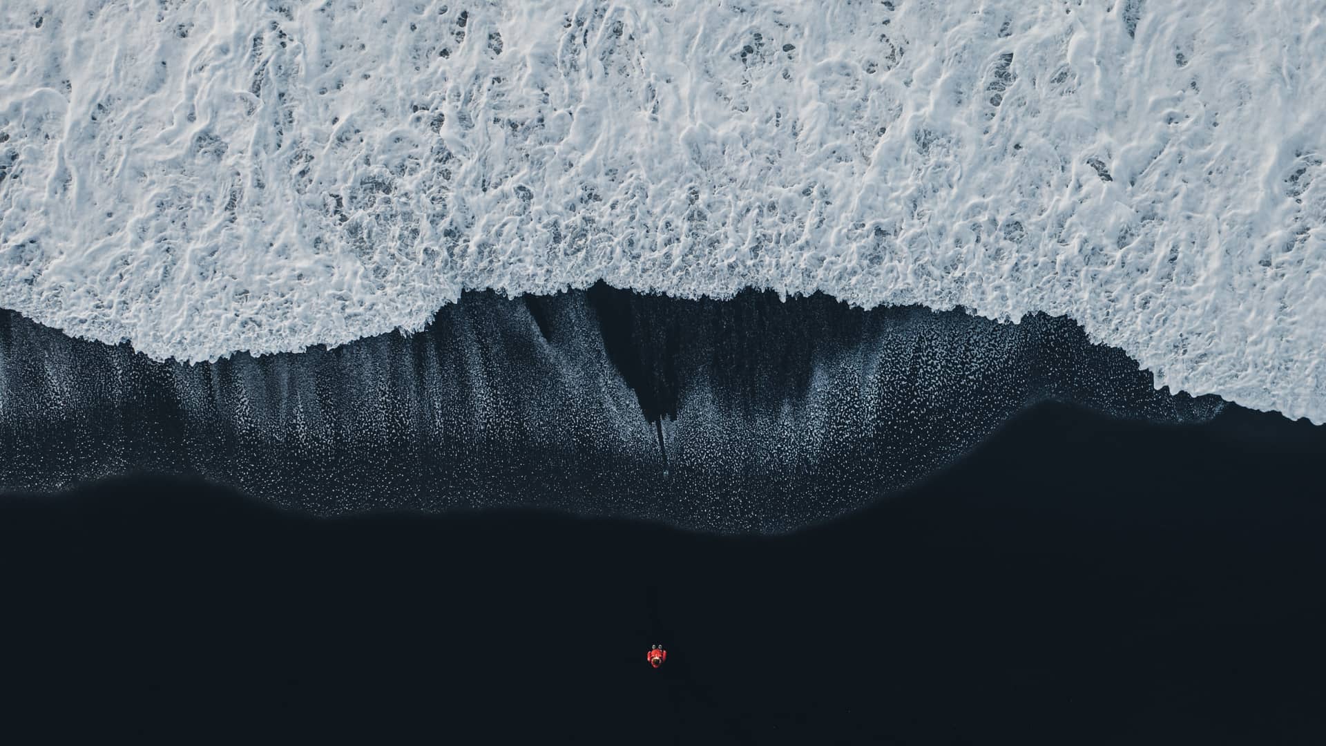 Vista aérea de una ola rompiendo en una playa representando a la energía undimotriz
