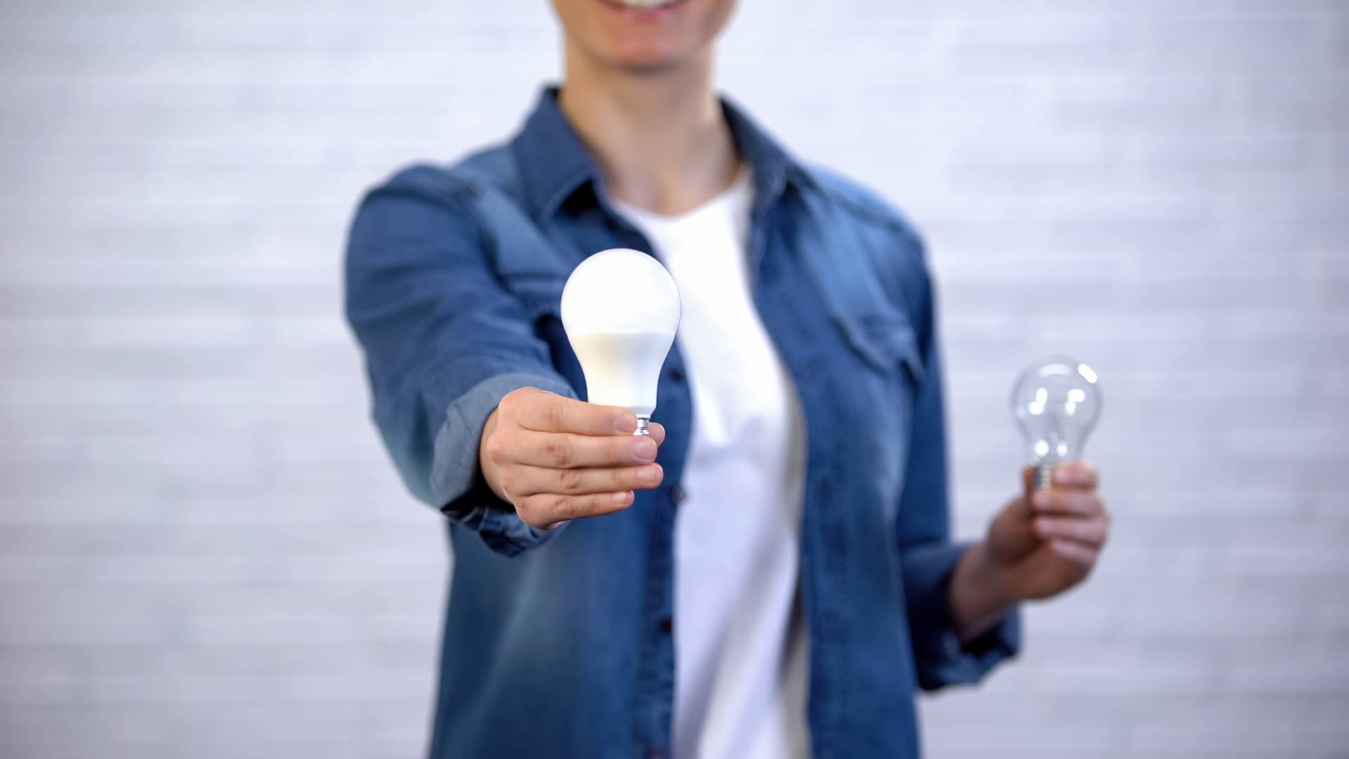 Mujer que va a cambiar las bombillas normales por led para tener un ahorro energético